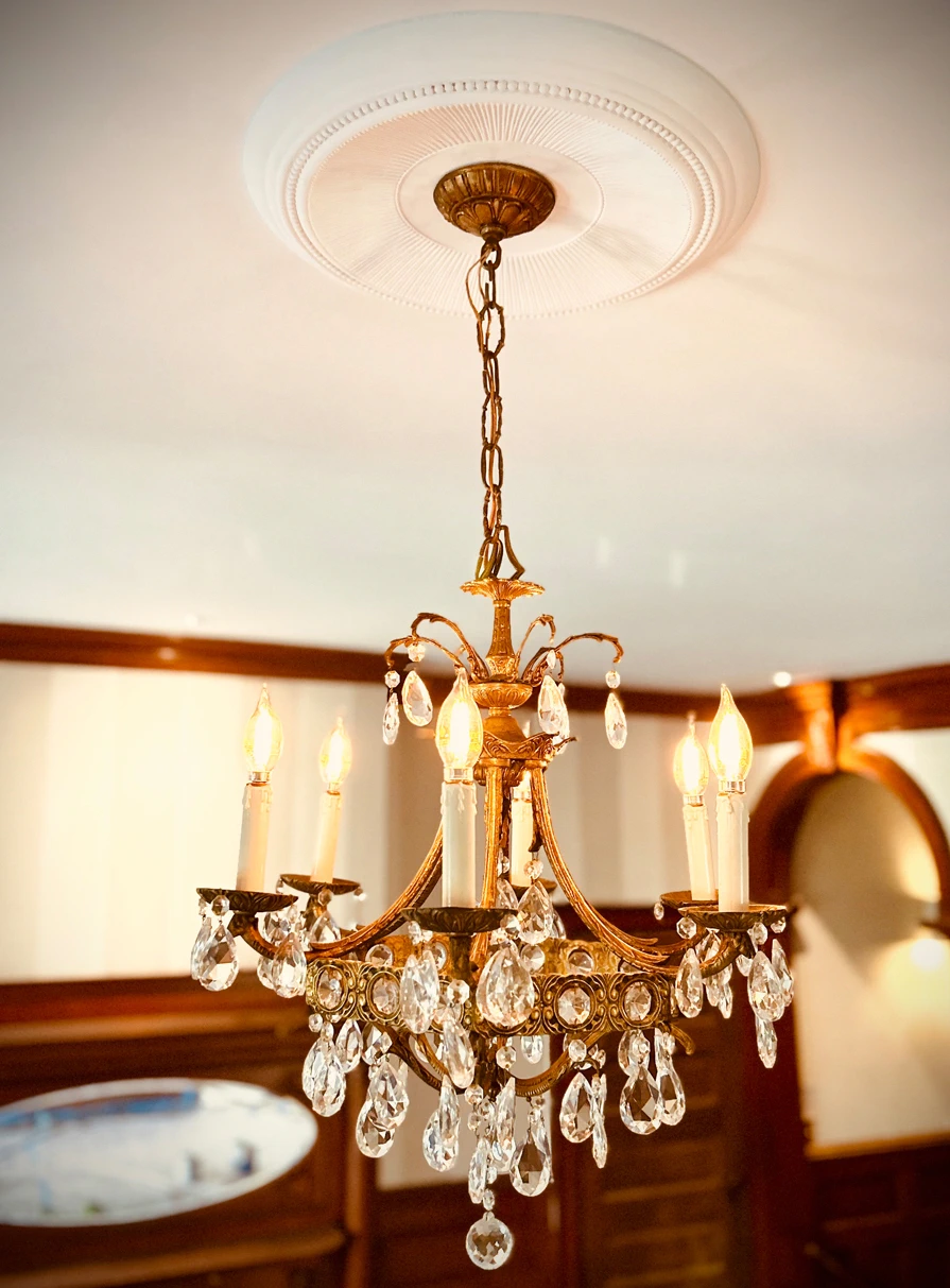 Crystal chandelier at Idylease suspended from a decorative plaster ceiling medallion